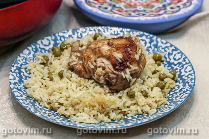 Куриные бедра на сковороде с рисом и зеленым горошком. Фотография рецепта
